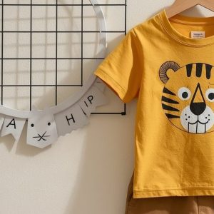 Toddler boys' camel brown pocket t-shirt and cream bison print shorts set flat lay.